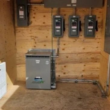 Utility meters and electrical panel inside a wooden enclosure.