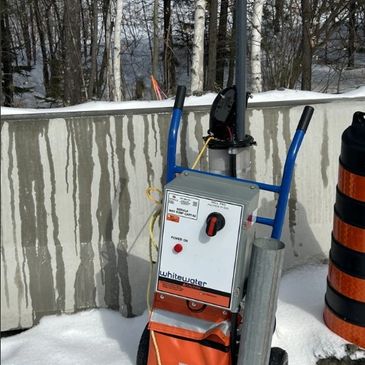 Electrical equipment on a dolly in snowy outdoor setting.