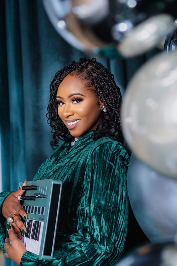 Woman smiling with a small keyboard instrument.