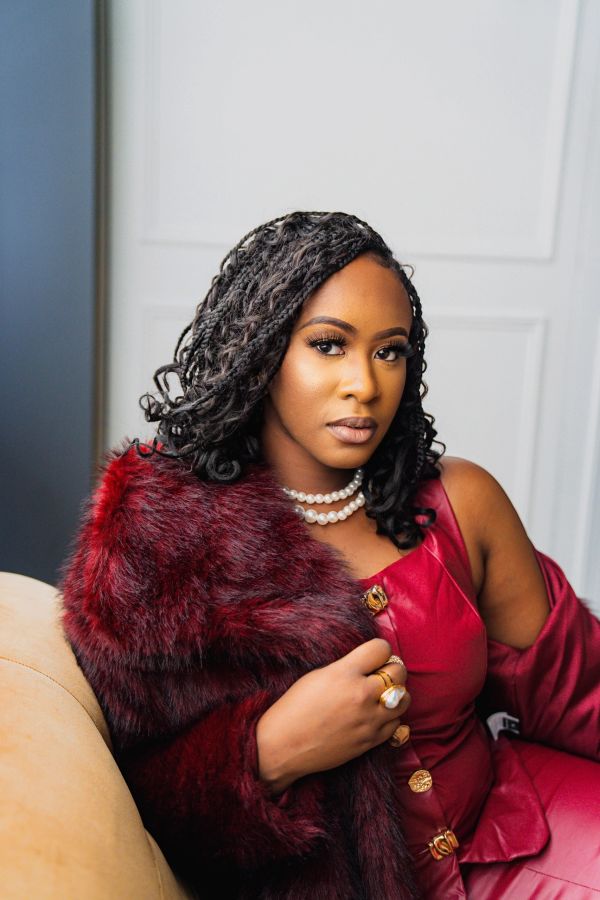 Woman in stylish red outfit and fur stole.