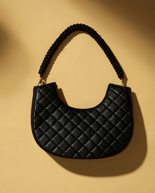 Black quilted handbag with textured handle.