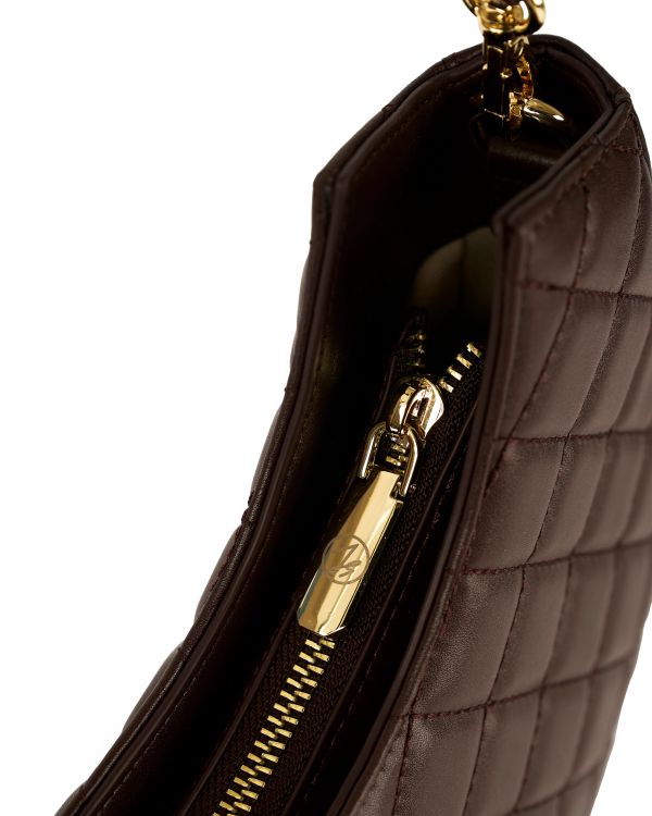 Close-up of a quilted brown leather bag with a gold zipper.