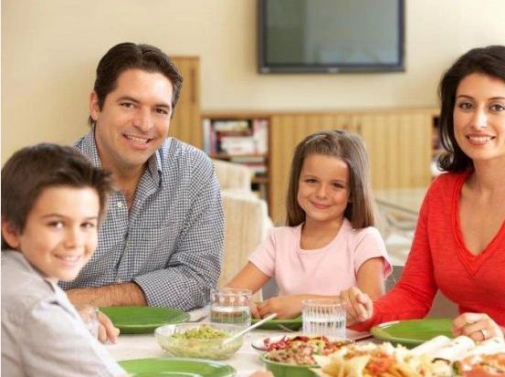 A happy family enjoying a meal together at the dining table.