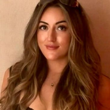 Young woman with long wavy hair and a subtle smile.