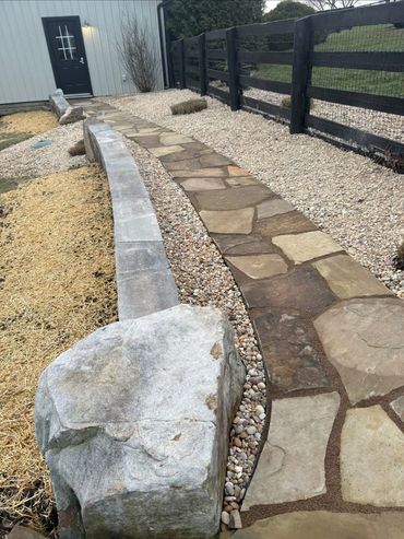 Stone pathway lined with rocks and gravel.