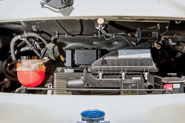 Photo of the engine bay of an RV for sale, showing mechanical condition