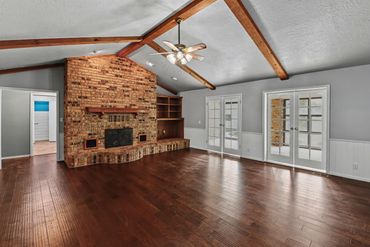 Real estate listing photo of a room with hardwood floors and fireplace in a home for sale western OK