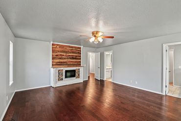 Real estate photographer in western Oklahoma took this photo of  bedroom w/hardwood floors fireplace