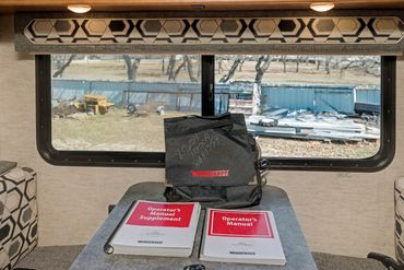 Photo of a rear window and table area inside an RV for sale