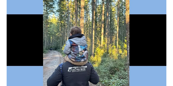 Person carrying child in forest with Losi Pro Wash logo and contact info above.
