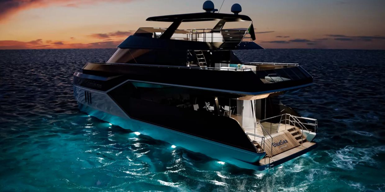 Luxury yacht illuminated at dusk on calm ocean waters.