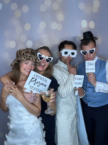 Four people in fun costumes and props posing happily at a party.