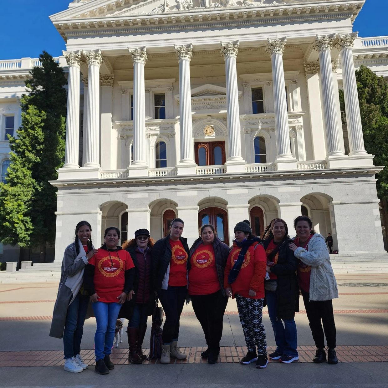 Group of women posing in front of a historic government building.