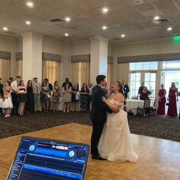 Bride and groom sharing first dance at wedding reception.
