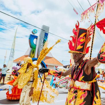 Colorful dancers in vibrant costumes perform at a lively outdoor festival.