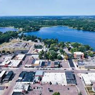 Aerial view of a town near a large lake with surrounding greenery.