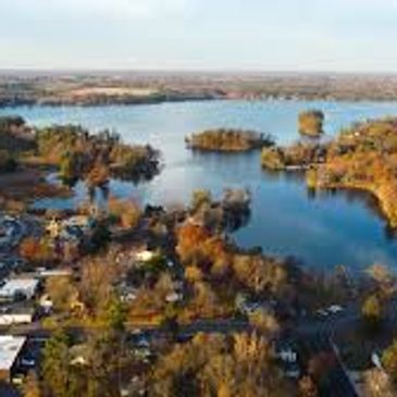 Aerial view of a river with surrounding trees and houses.