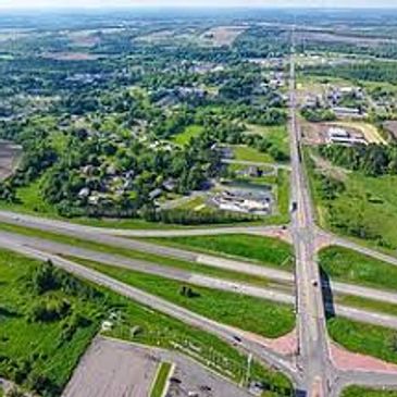 Aerial view of a highway intersection surrounded by greenery and buildings.