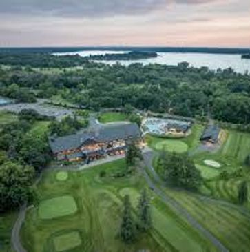 Aerial view of a golf course with clubhouse near a river.