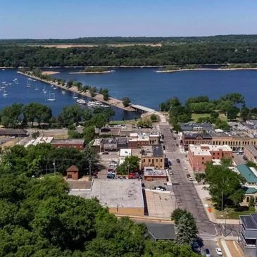 A small town with a bridge crossing a lake and boats docked nearby.