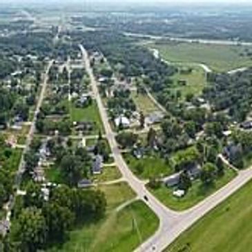 Aerial view of a small town with roads, houses, and greenery.