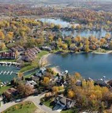 Aerial view of a lakeside residential area with autumn foliage.