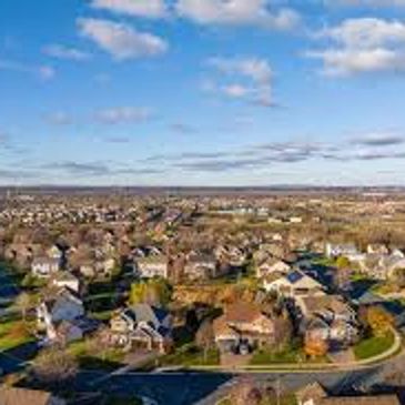 A suburban neighborhood under a partly cloudy sky.
