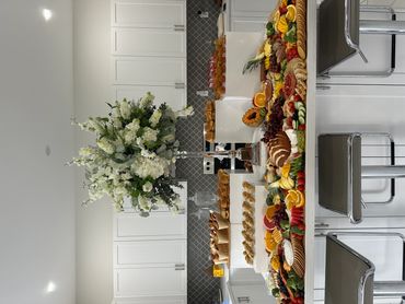 Elegant kitchen setup with a large floral centerpiece and an array of beautifully arranged food platters.