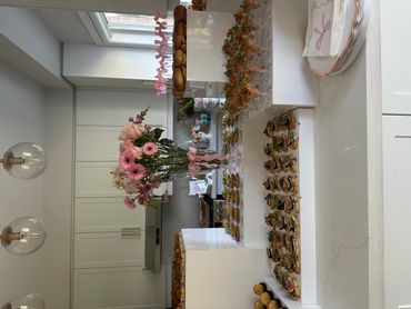 Elegant kitchen setup with a floral centerpiece and an array of neatly arranged appetizers.