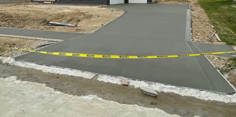 Damaged concrete driveway in Papillion NE after Kinnan Scaping skid loader drove on new concrete
