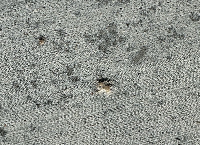 Cracked and damaged concrete driveway in Omaha NE two years after Kinnan Scaping skid loader damage
