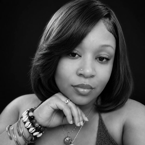 Black-and-white portrait of a young woman with jewelry.