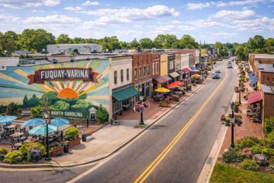 Main street of Fuquay-Varina, North Carolina with colorful mural and shops.