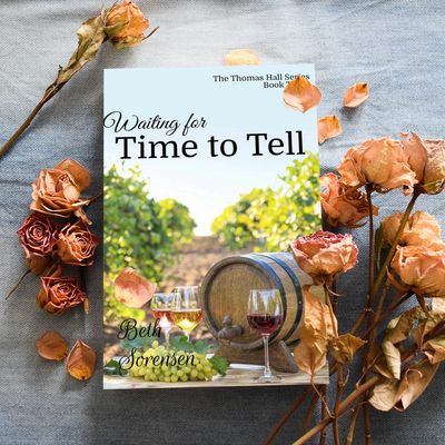 A book titled "Waiting for Time to Tell" surrounded by dried roses and petals.
