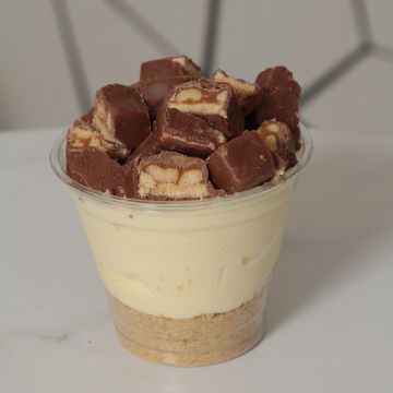 Cheesecake cup with crumble and Snickers topping