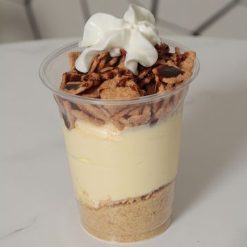 Cheesecake cup with cinnamon toast crunch, chocolate, & whipped cream