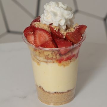 Cheesecake cup with crumble, strawberry shortcake, & whipped cream topping