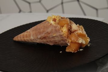 Cheesecake in a cone with peach cobbler