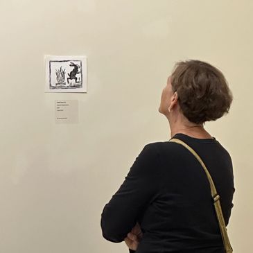 A visitor looks at artwork by DeLesslin George-Warren.