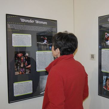 A visitor reads an exhibit banner in a gallery.