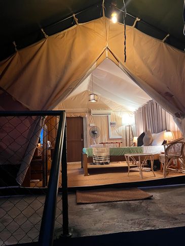 Cozy illuminated tent interior at night.