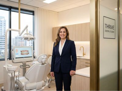 A female dentist stands confidently in a modern dental office.