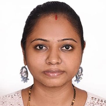 Portrait of a woman with traditional earrings and a bindi.