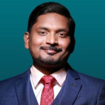 Smiling man in a suit and red tie.