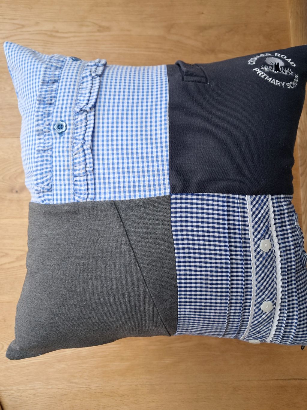 A memory cushion made from 4 squares of blue and grey school uniform