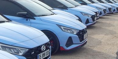 Line of blue Hyundai cars parked in a row.
