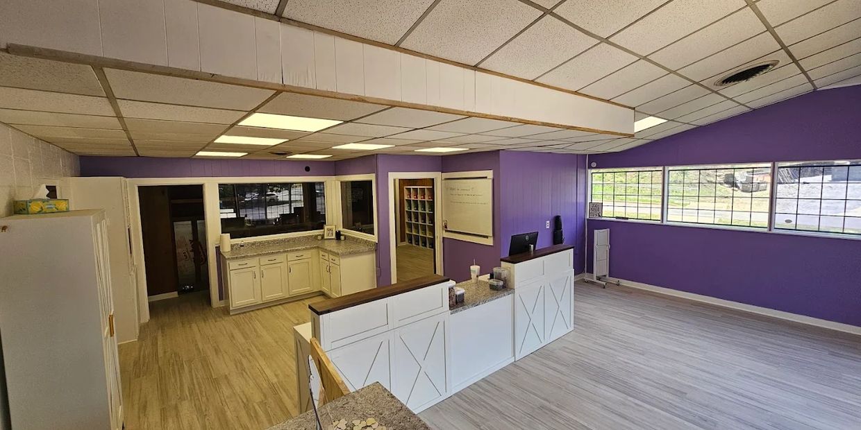 Bright office space with purple walls and white cabinetry.