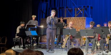 A jazz band performing on stage with a vocalist and various musicians.