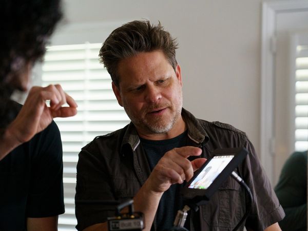 Man interacts with a touchscreen device indoors.