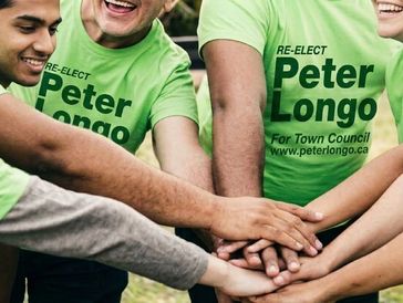Group wearing campaign shirts stacking hands together.